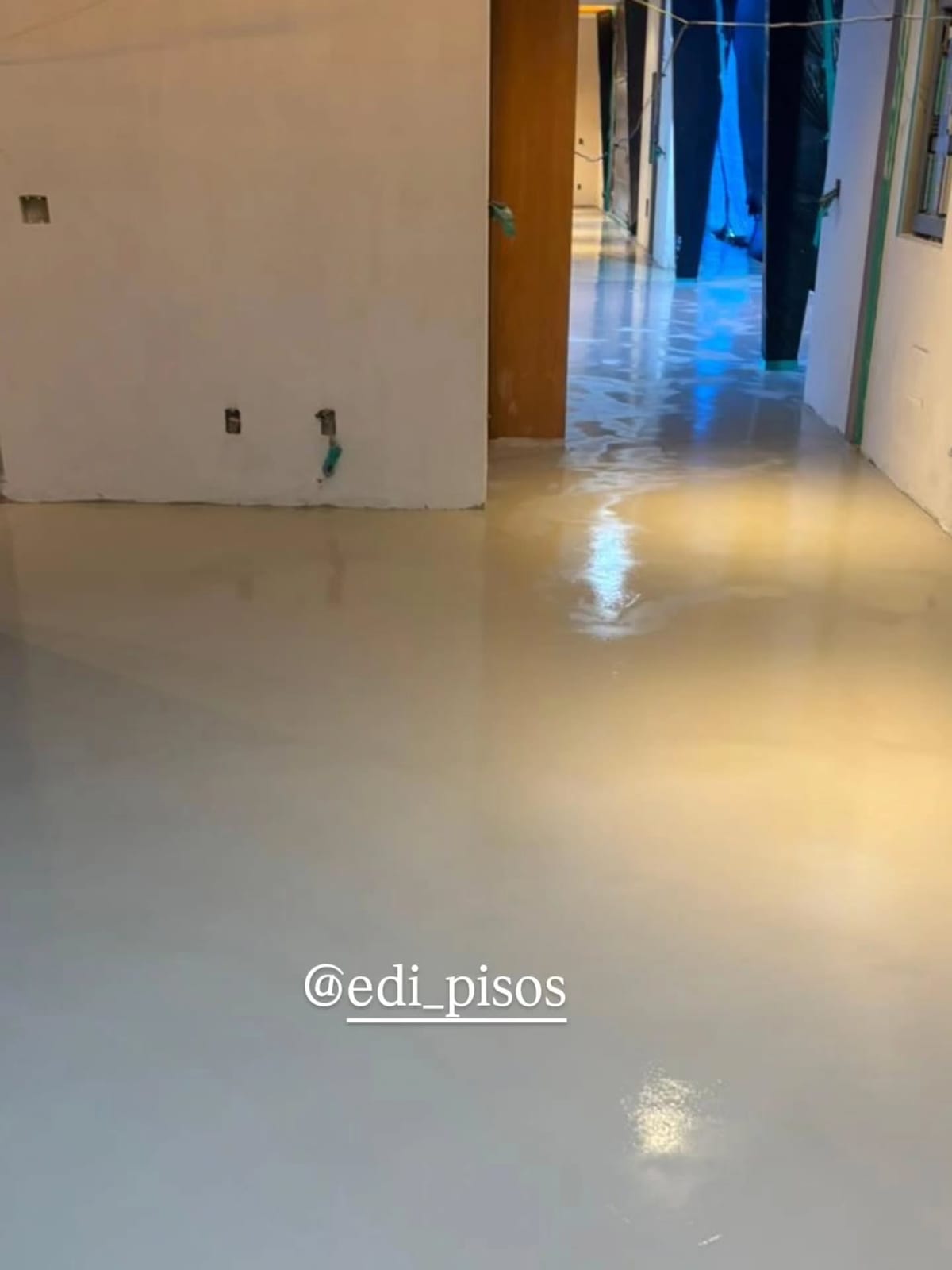 Piso resinado autonivelante recém-aplicado em corredor de edifício em obra, em Cerqueira César