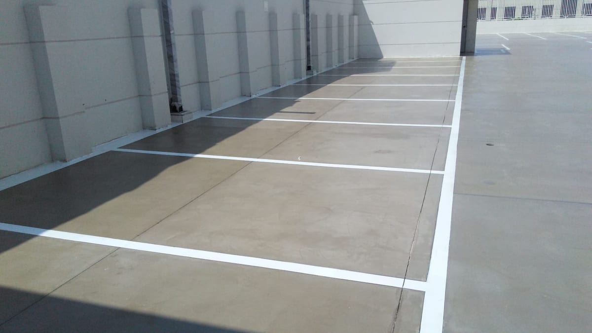 Piso contínuo do estacionamento com linhas de vaga pintadas em branco