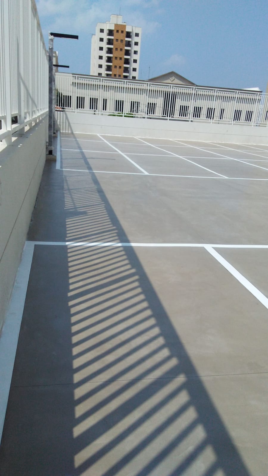 Enquadramento vertical do piso do estacionamento, mostrando a faixa de circulação
