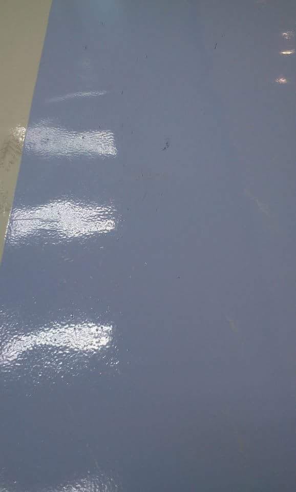 Encontro do piso branco com a faixa azul, em detalhe